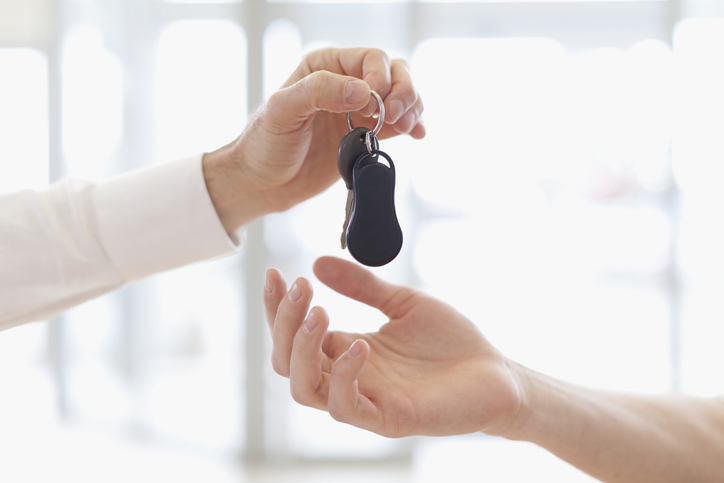 Car salesman handing keys to customer